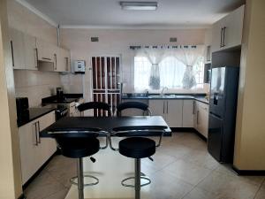 a kitchen with a table and chairs in it at Ivy Cottage in Harare