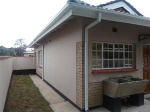 a house with a sink in the side of it at Ivy Cottage in Harare