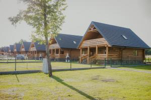 a large log cabin with a tree in front of it at Hawiry Nad Dylą in Głębockie Pierwsze