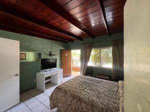 a bedroom with a bed and a flat screen tv at Motel Maya in Tijuana