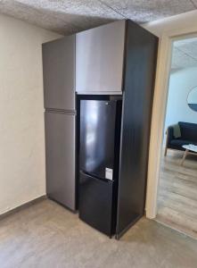 a black refrigerator in the corner of a room at Bredgade 38 - Downstairs in Sønder Felding