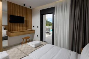 帕奇斯Thea Luxury Living的一间带床、电视和阳台的卧室 更多46张照片