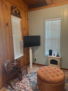 a living room with a flat screen tv and a chair at 107 Vinewood Cabin-1 Bedroom in Brewton