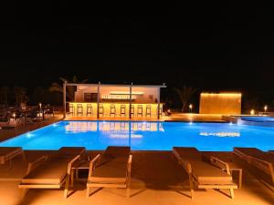 a large pool with chairs and a building at night at Pachia Ammos Falasarna in Falasarna