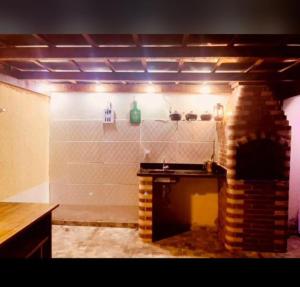 a room with a brick fireplace and a counter at Itaipuaçu Central in Maricá
