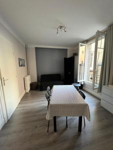Studio cosy proche parcs, opéra, centre ville في فيشي: غرفة معيشة بها طاولة وأريكة +7 صور
