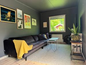 un soggiorno con un divano e un tavolo di Cosy cabin w fireplace 3 mins from Söderåsen Park a Ljungbyhed