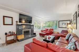 Una sala de estar con muebles rojos y chimenea. en Historic SW Portland Sanctuary, en Portland