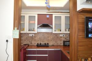 a kitchen with white cabinets and a counter top at Ananta Square - Rishikesh 1BHK in Rishīkesh