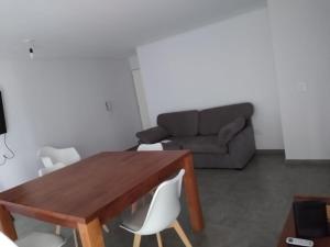 a living room with a wooden table and a couch at Departamento céntrico amplio in Río Cuarto