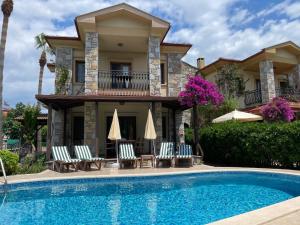 a villa with a swimming pool in front of a house at Villa Caretta Luna in Ortaca
