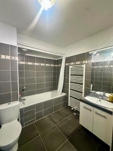 a bathroom with a toilet and a tub and a sink at Cosy Perpi Gare in Perpignan