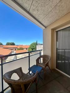 a balcony with two chairs and a view of a building at Cosy Perpi Gare in Perpignan