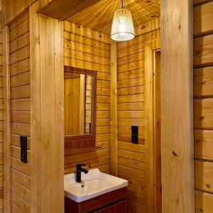 a bathroom with a sink and a mirror at أكواخ القرية -VILLAGE HUTs in Taif