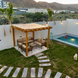 a gazebo sitting on top of a yard at أكواخ القرية -VILLAGE HUTs in Taif