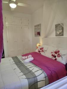 a bedroom with a bed with pink shoes on it at location appartement isla plana espagne in Isla Plana +24 photos