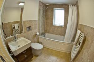 Un baño con bañera, inodoro y lavabo. en Luxury 2 bedroom Flat with Parking and 2 bathrooms, en Norwich