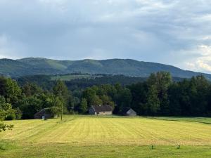 an open field with a house in the middle of it at Słoneczny domek 