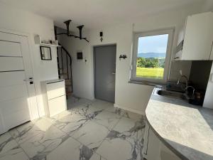 a kitchen with marble floors and a window at Słoneczny domek 