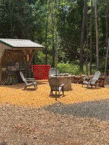a group of chairs sitting next to a fire pit at 109 Vinewood Cabin-1 Bedroom in Brewton