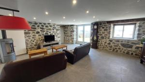 a living room with a couch and a television at Gite sur les hauteurs de Cassuéjouls in Cassuéjouls