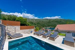 a pool with chaise lounge chairs and a swimming pool at Vacation home with Private heated Pool in Zaton