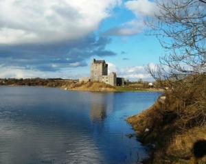 a castle on an island in a body of water at Aira Lodge Accommodation in Kinvara +8 photos