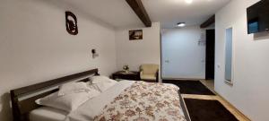 a bedroom with a bed with a blanket on it at Pensiunea Montan in Durău +4 photos