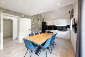 a kitchen with a wooden table and blue chairs at Vacation home with Private heated Pool in Zaton
