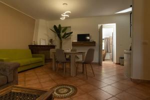 a living room with a table and a green couch at Anna House in Fiumicino