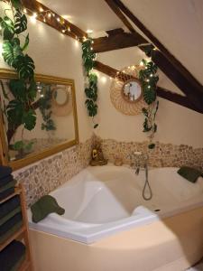 un bagno con una grande vasca e piante di Maison Les Géraniums parking privé moto a Linthal Altre 39 foto