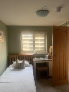 a bedroom with a bed and a desk and a window at The Angel Inn in Thirsk