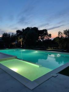 a large swimming pool at night with lights in it at Tenuta Victoria in Sava