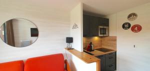 a kitchen with a red couch and a mirror at Pieds des pistes - Parking couvert - Plein sud in L'Alpe-d'Huez