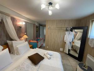 una camera da letto con un grande letto bianco e uno specchio di Gîte 1 à 6 personnes Rez de jardin de la villa piscine et sauna à partager Jacuzzi en option a Sarlat-la-Canéda Altre 50 foto