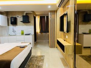 a bedroom with a bed and a sink and a tv at The Darling Studio in Dehradun +3 photos