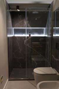 a bathroom with a glass shower with a toilet at Dimora Ai Leoni, Suite & Apartments in Palermo