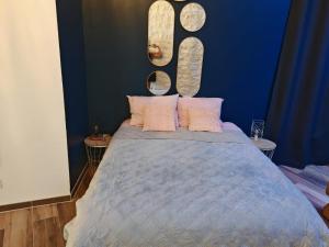 Schlafzimmer mit einem Bett mit zwei Spiegeln an der Wand in der Unterkunft appartement cosy in Villefranche-sur-Saône + 3 Fotos
