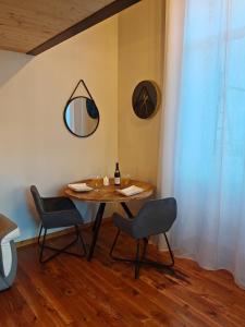 einen Esstisch mit 2 Stühlen und einem Spiegel in der Unterkunft appartement cosy in Villefranche-sur-Saône