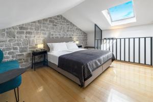 a bedroom with a bed and a stone wall at Vacation home with Private heated Pool in Zaton