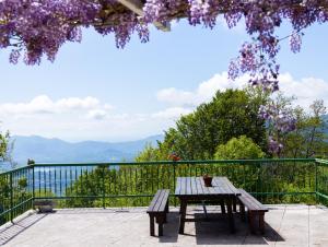 a picnic table on a patio with a view of the mountains at Borgata Giostra in Caprie +23 photos