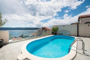 a swimming pool on top of a building with a view of the water at House Mimica in Stanići