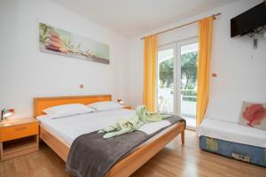 a hotel room with two beds and a window at House Mimica in Stanići