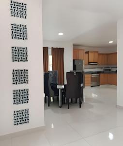 a kitchen and dining room with a table and chairs at Casa cerca del aeropuerto. in Monte Llano