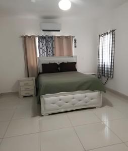 a bedroom with a bed with a green comforter at Casa cerca del aeropuerto. in Monte Llano