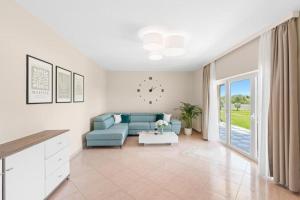 a living room with a blue couch and a table at Apartment Vista Olivo in Brtonigla