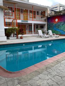 a hotel with a swimming pool in front of a building at El Rincón de Granada Casa de Huespedes in Cali