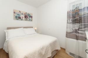 a bedroom with a white bed and a painting on the wall at Villa Jolanda in Plano +58 photos