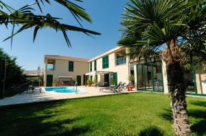 a house with a palm tree in the yard at Villa Jolanda in Plano