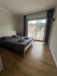 a bedroom with a large bed and a large window at Les Balcons du Couloubret in Ax-les-Thermes